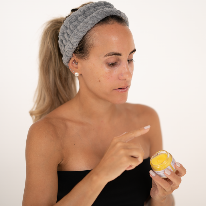 girl putting finger in glas with arrivacell intensiv pflegebalsam