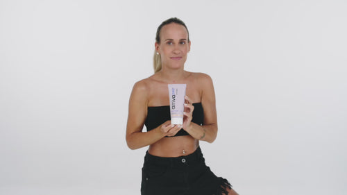 girl showing summerskin body lotion and uses it on her arm and leg