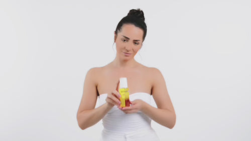 girl showing and using golden glow sun spray