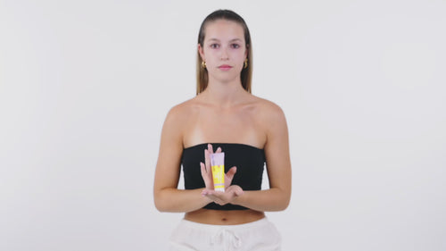 girl showing sun face cream and using it on her face
